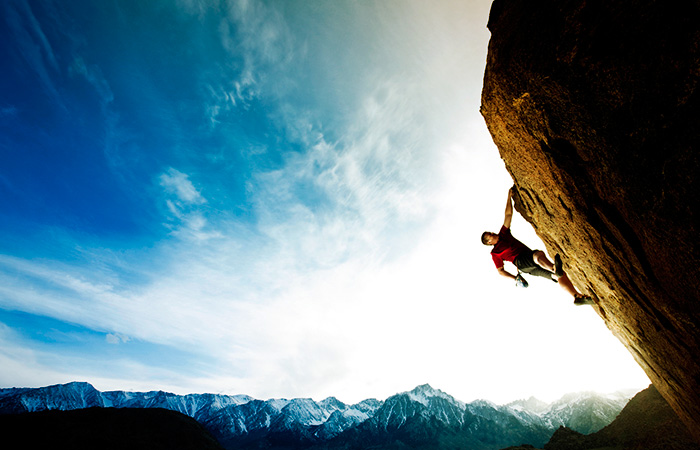 Mountain climber ascending steep cliff